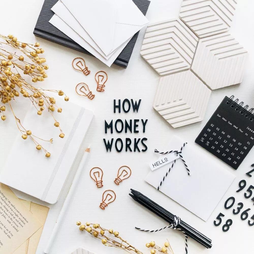 Top view of desk with letters saying "how money works"